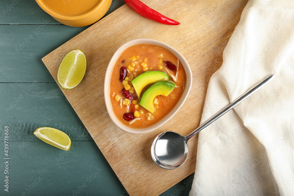 Bowl of tasty chicken enchilada soup on table