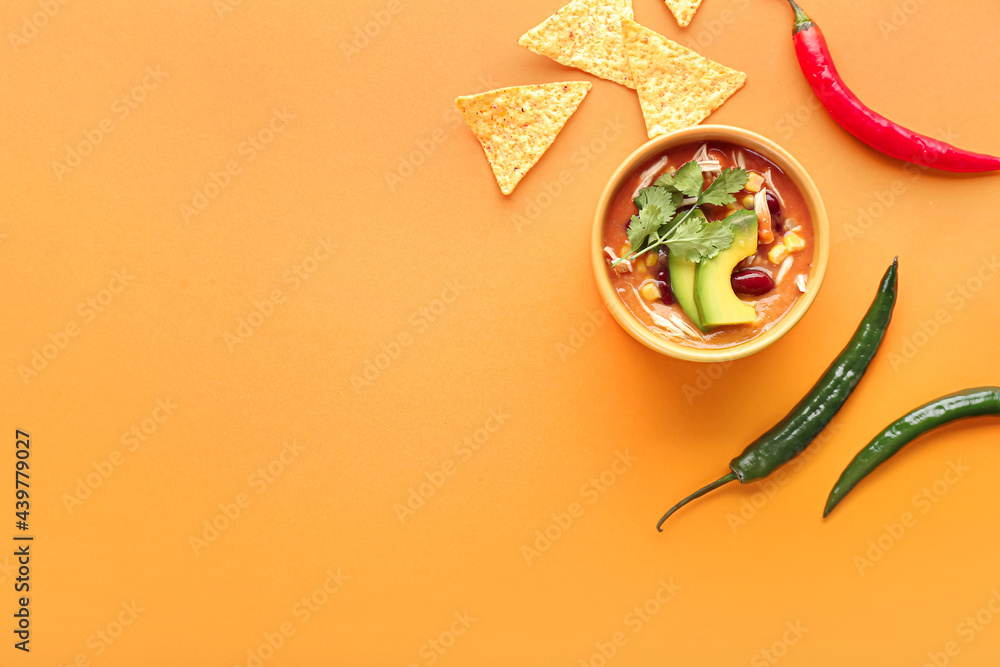 Bowl of tasty chicken enchilada soup on color background