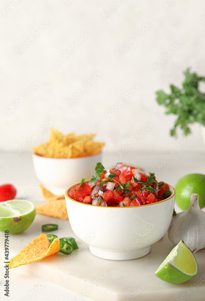 Bowl of tasty Pico de Gallo salsa and nachos on table