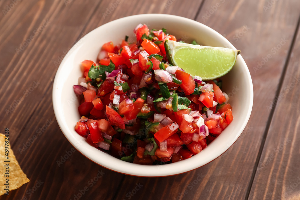 Bowl of tasty Pico de Gallo salsa on table