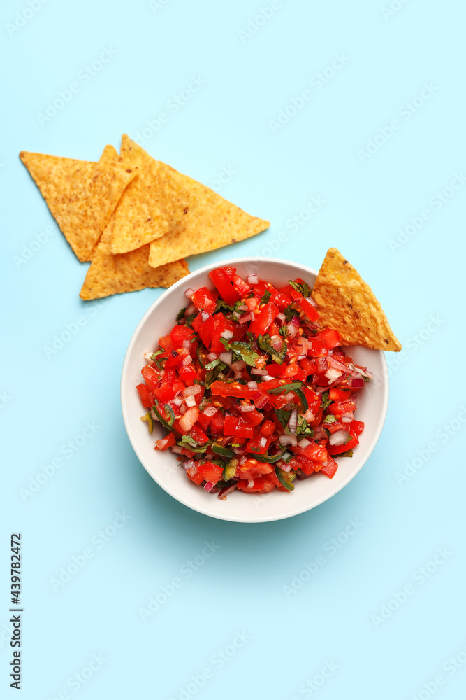 Bowl of tasty Pico de Gallo salsa and nachos on color background