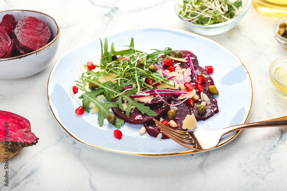 Plate with delicious beetroot carpaccio on light background