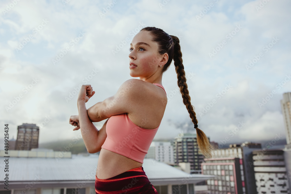 Woman doing warmup stretches on rooftop