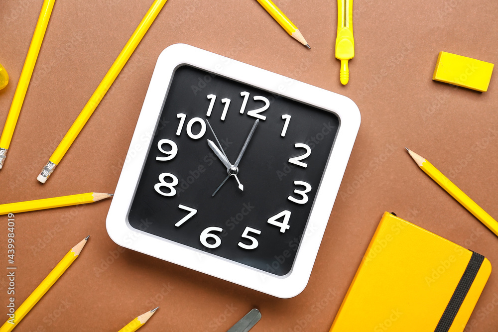 Composition with stylish clock and stationery on color background