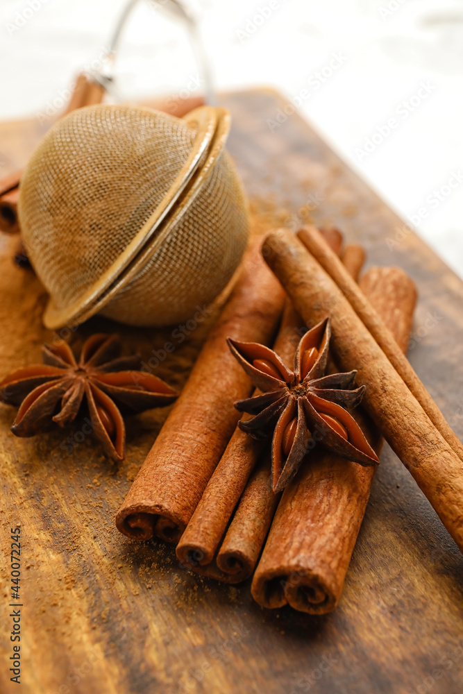 Tea strainer and aromatic cinnamon on table