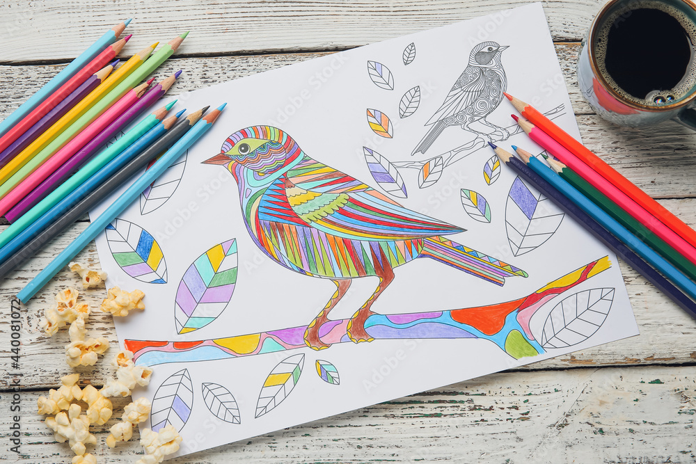 Composition with coloring picture on light wooden table