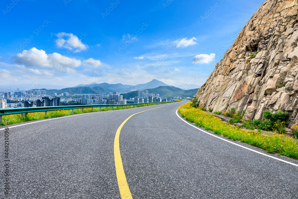 沥青公路和山脉，拥有现代城市天际线的风景。