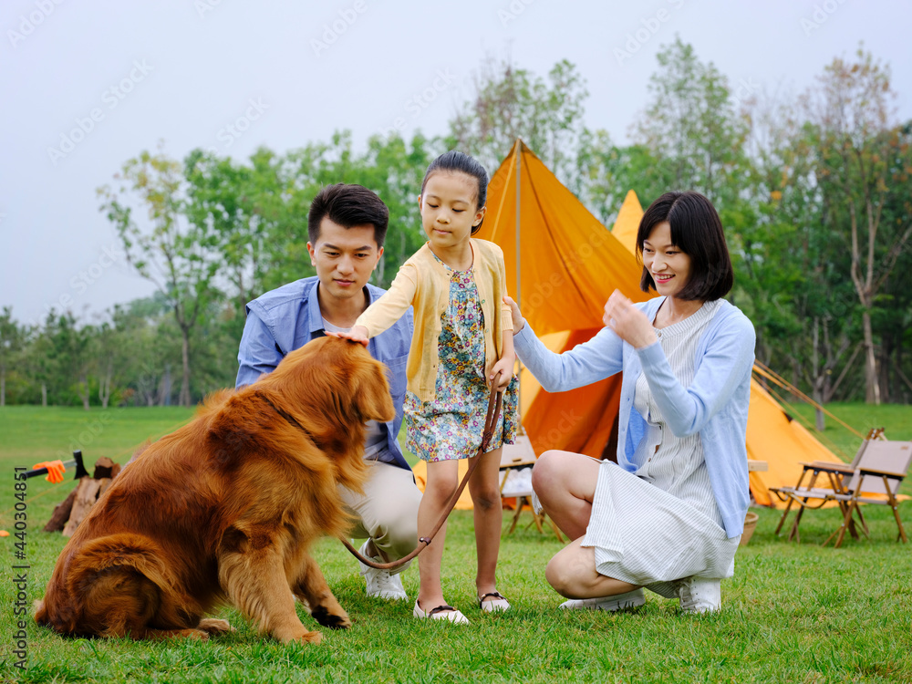 Happy family of three and dog camping out