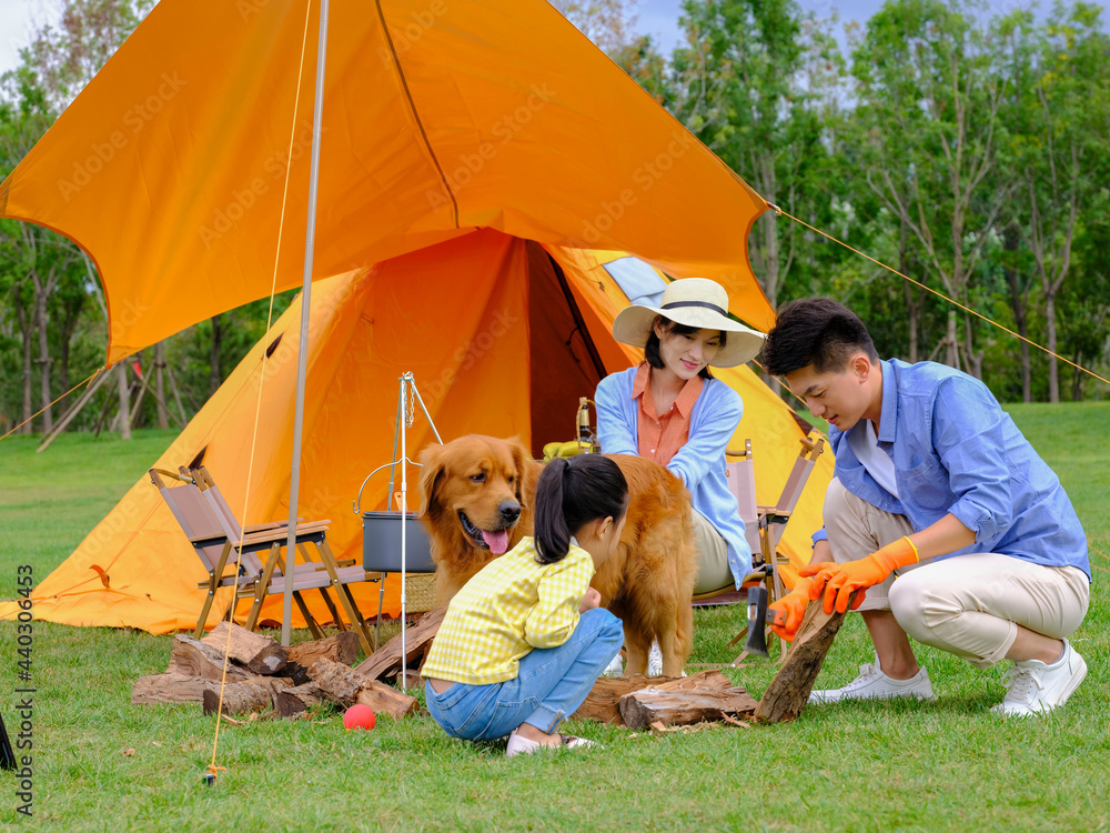 Happy family of three and dog camping out