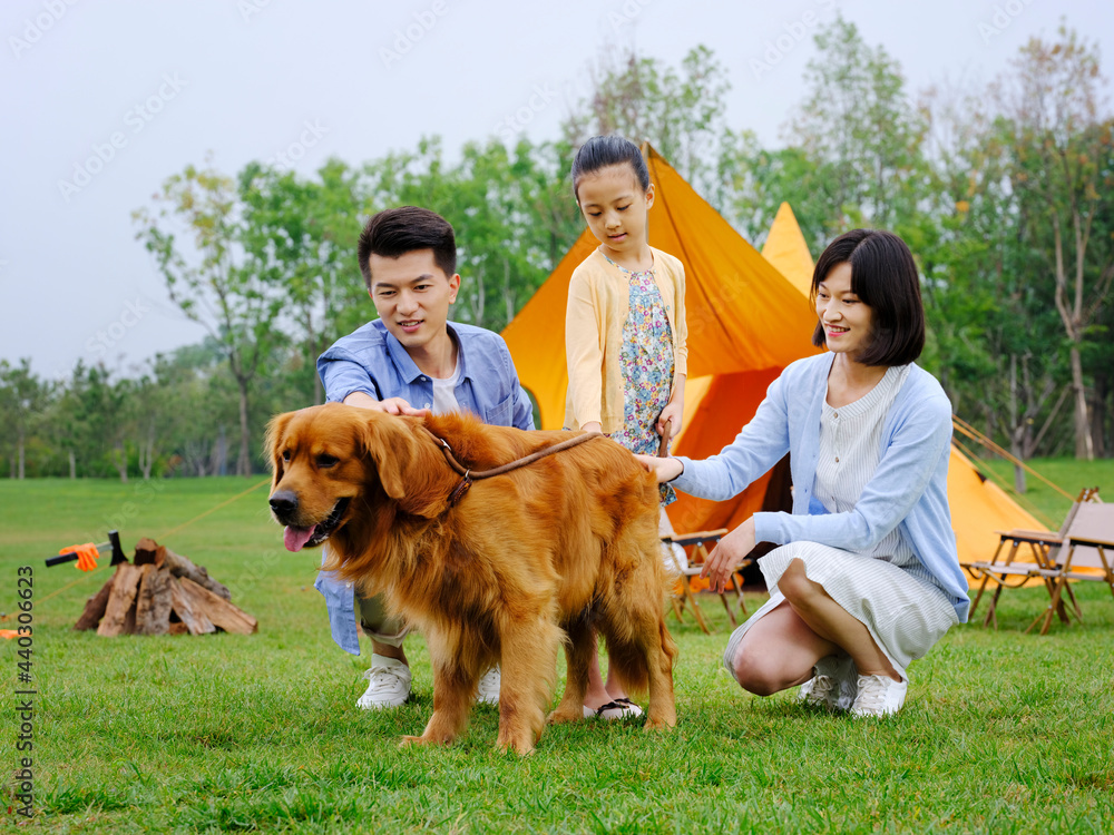 Happy family of three and dog camping out