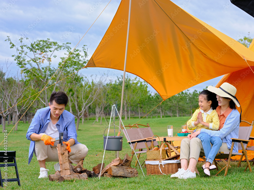 Happy family of three camping outdoors