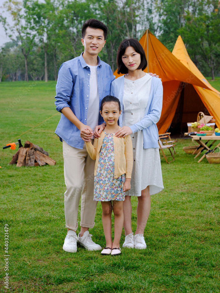 A Happy family of three camping outdoors