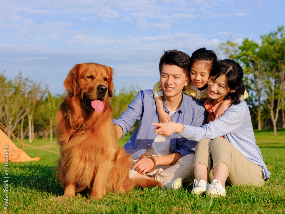 Happy family of three and pet dog in the park