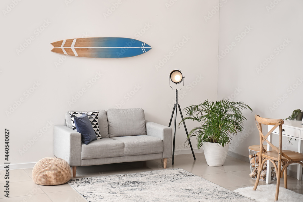 Interior of modern stylish room with surfboard and sofa