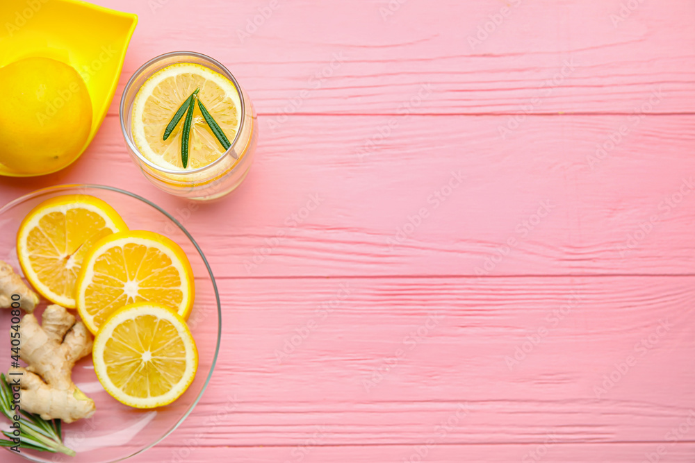 Glass of healthy lemonade and squeezer on color wooden background