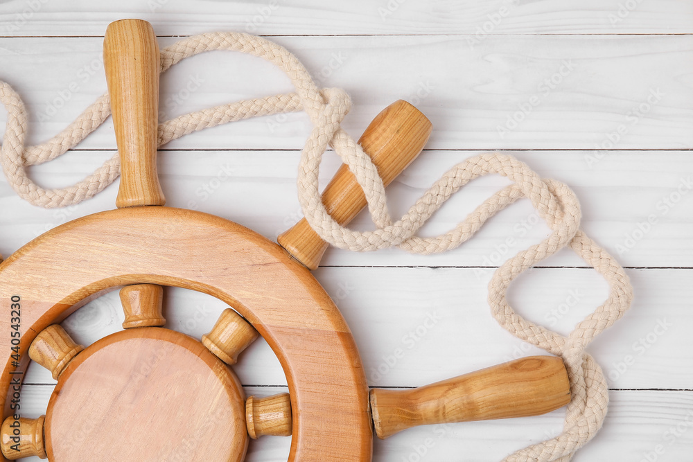 Helm and rope on white wooden background