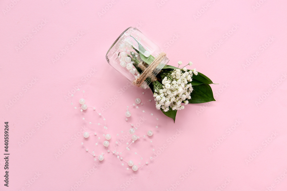 彩色背景上有美丽的gypsophila boutonnieres和珠子的罐子