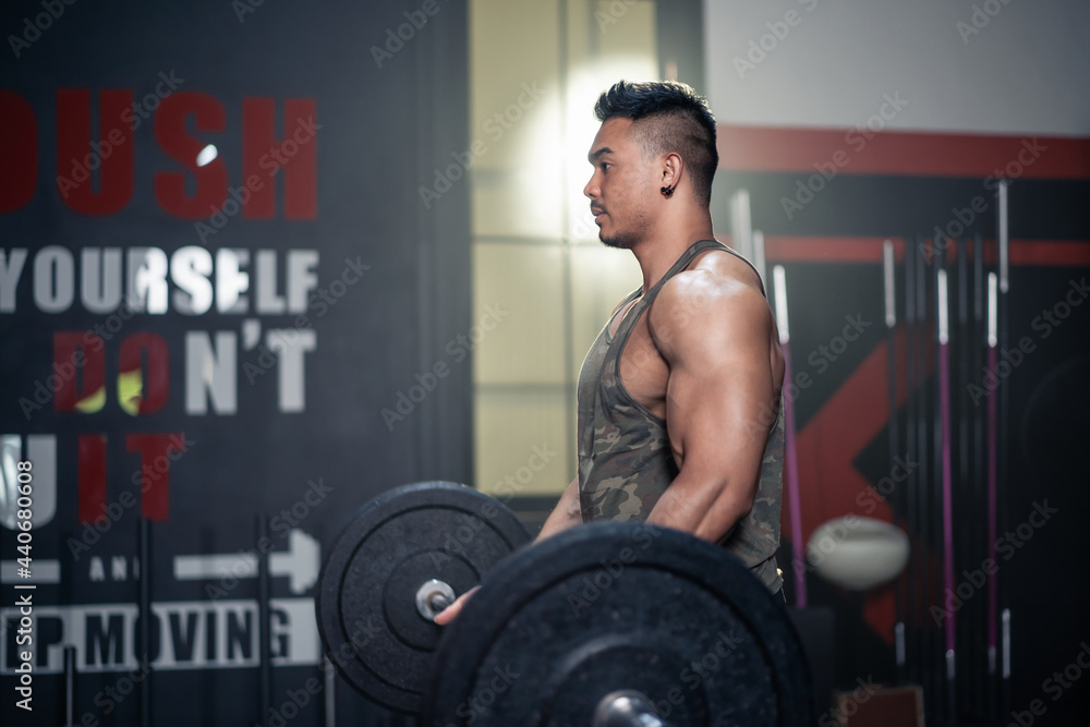 Asian Sportsman exercise, lift weight to build muscle and bicep in gym