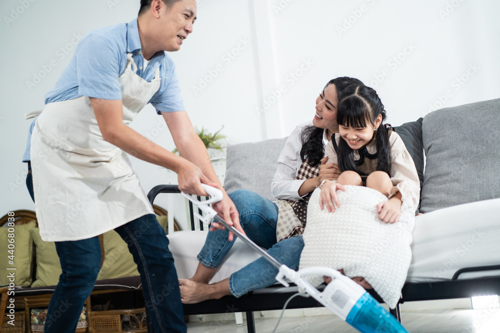 Asian happy family, parent teach young daughter clean room in home.