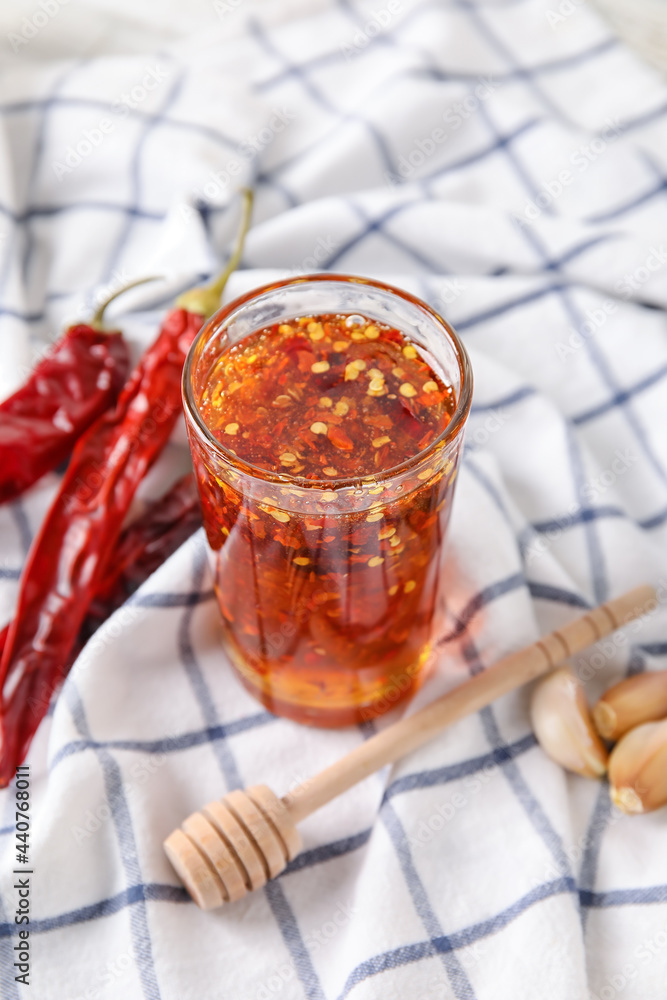 Glass of hot honey on fabric background