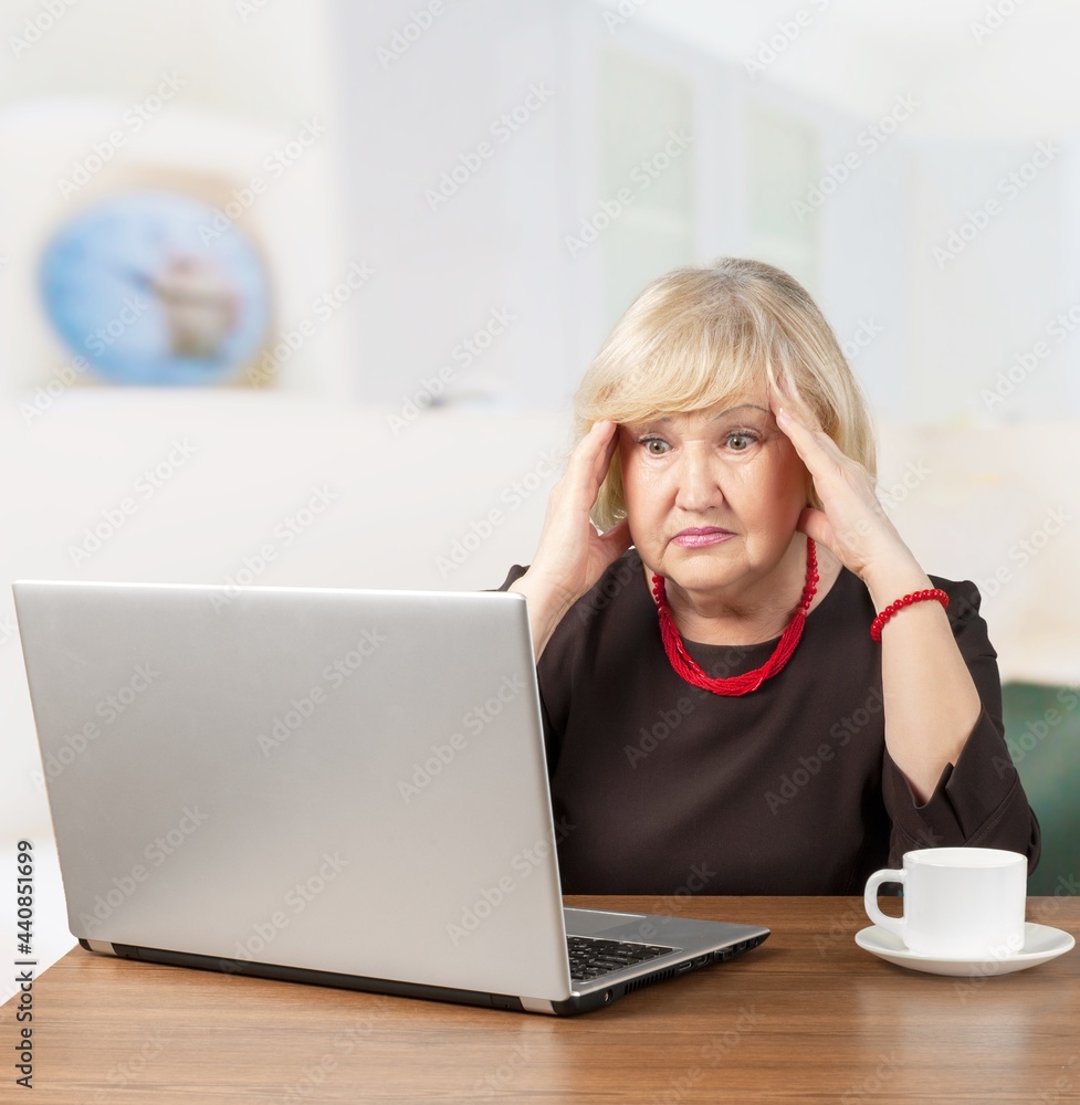 Stressed overworked business woman working from home from a laptop computer.