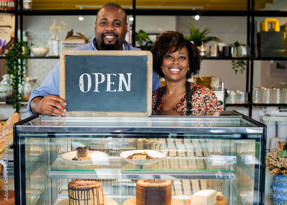 Cake cafe owners with open sign