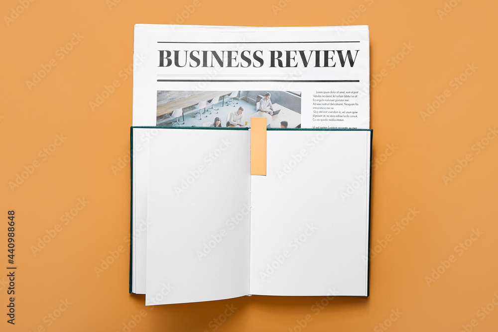 Book with bookmark and newspaper on color background