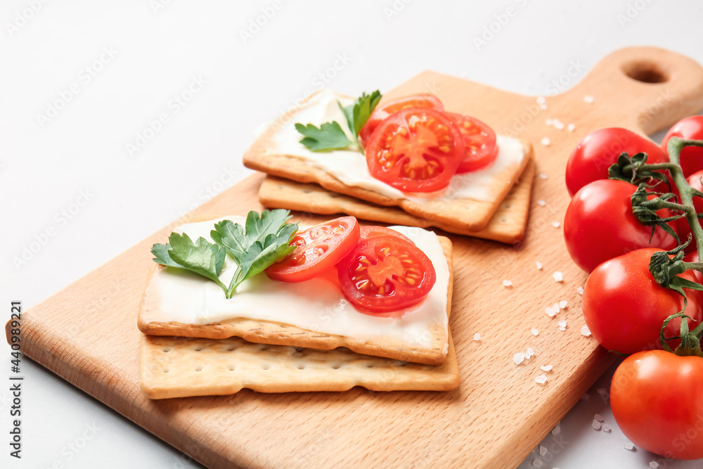 灰色背景上有美味的饼干和西红柿的木板，特写