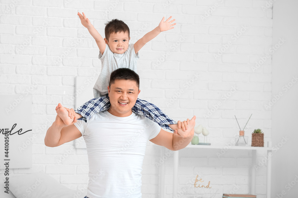 Morning of happy father and his little son in bedroom