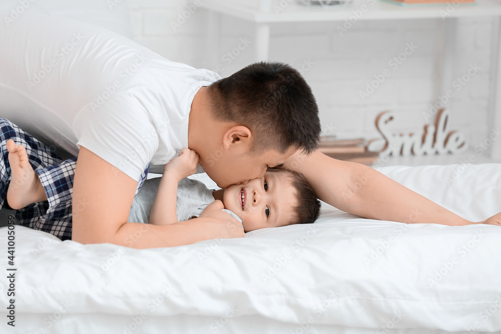 Morning of happy father and his little son in bedroom