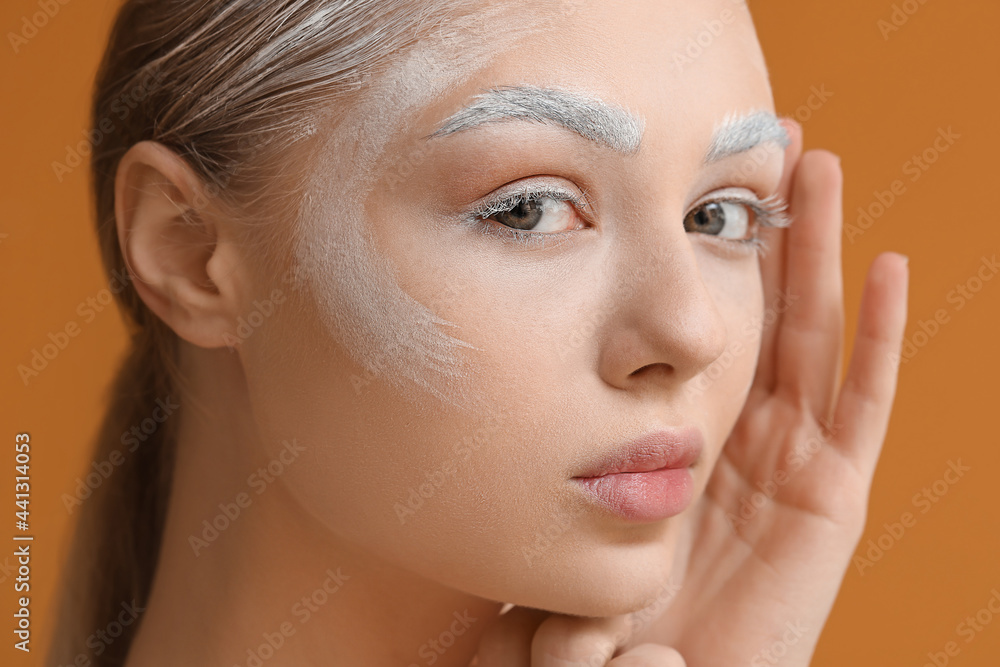 Beautiful young woman with dyed eyebrows on color background, closeup