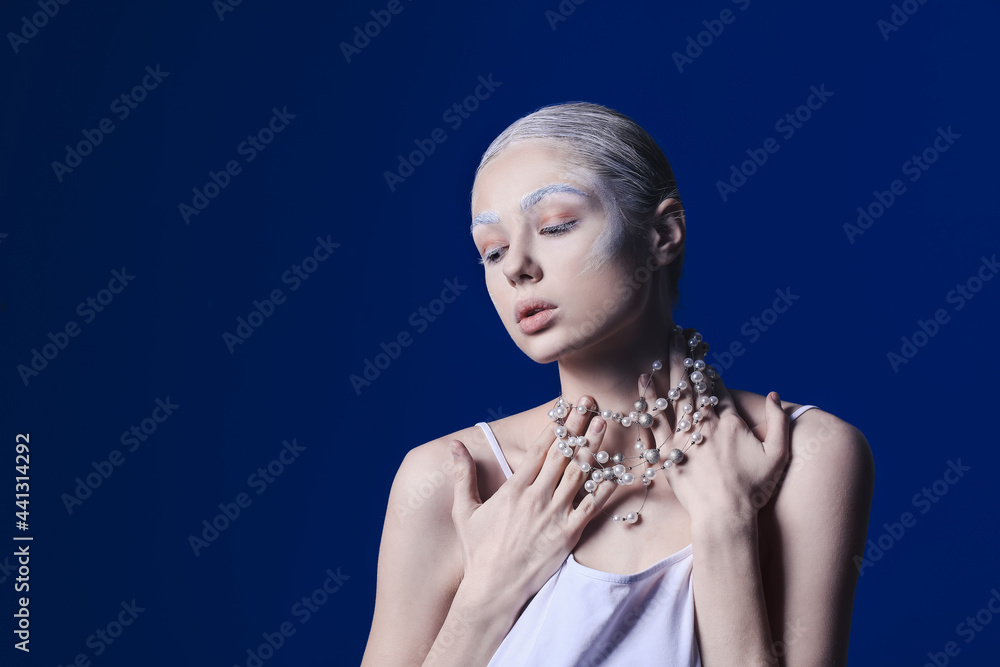 Beautiful young woman with dyed eyebrows and necklace on color background