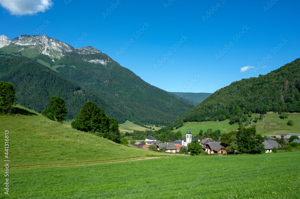 Paysage du Parc Naturel Régional des Bauges avec le village de La Compôte entouré de montagnes en Sa