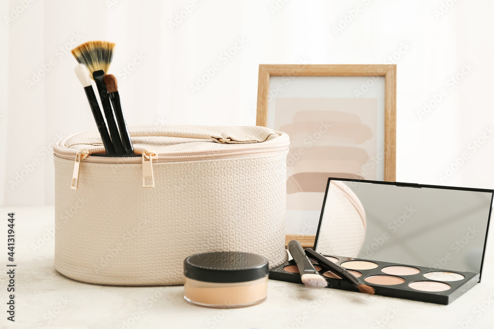 Stylish bag with decorative cosmetics on light background