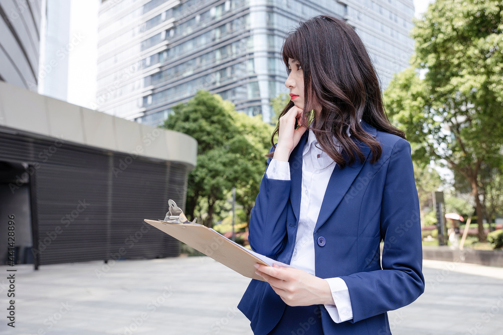 美丽的亚洲女人在户外，穿着西装