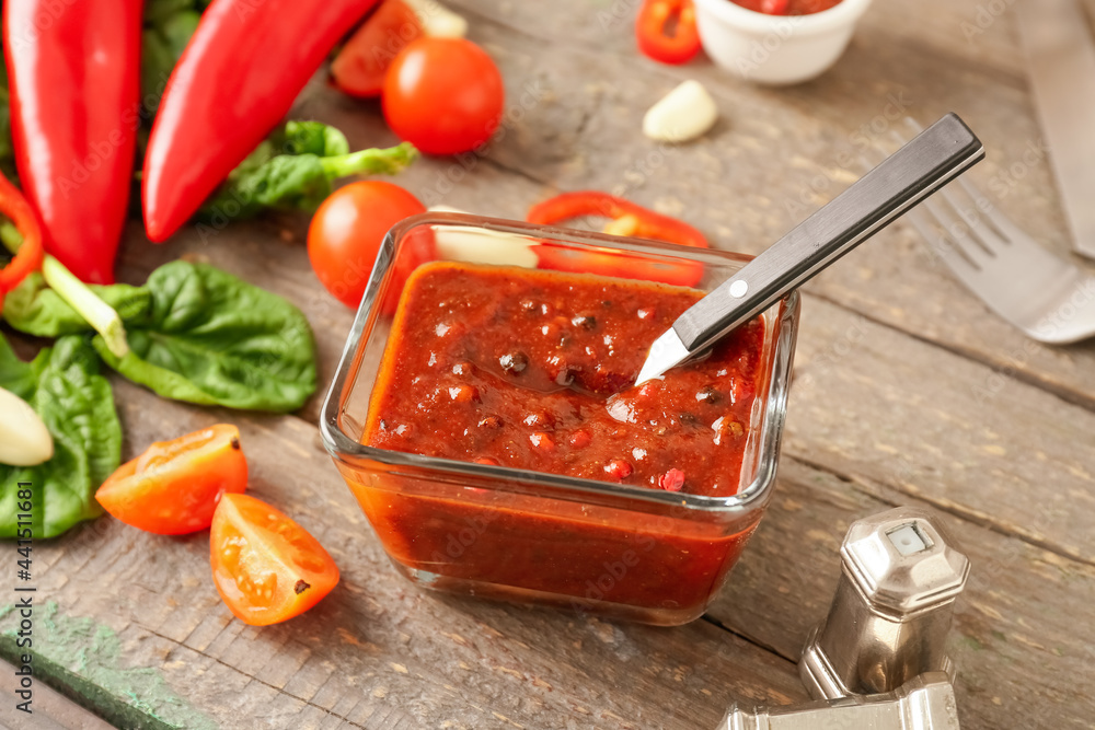 Bowl with peppercorn sauce and ingredients on wooden background