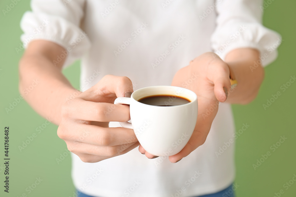 Woman with cup of coffee on color background, closeup