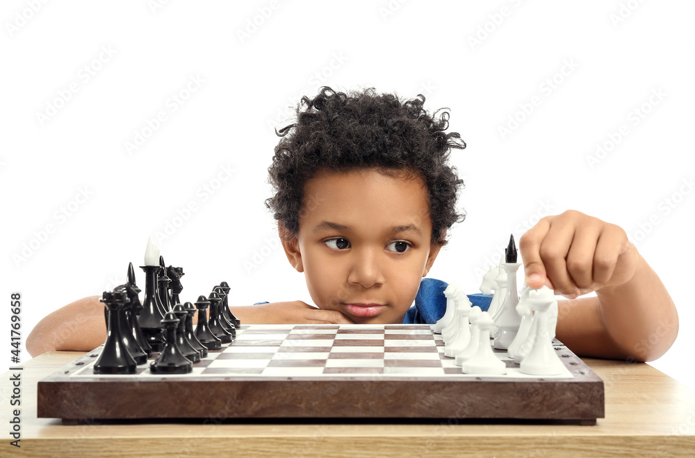 Cute African-American boy playing chess on white background