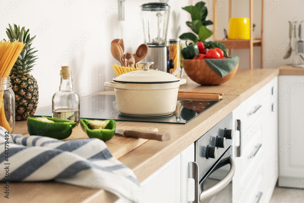 Cooking pot with pasta on stove in kitchen