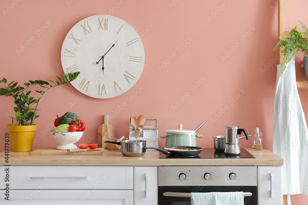 Modern electric stove and utensils in kitchen