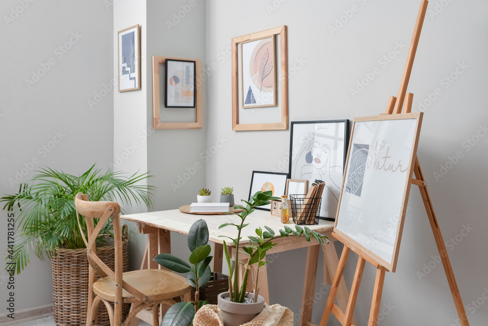 Interior of stylish room with modern workplace and pictures