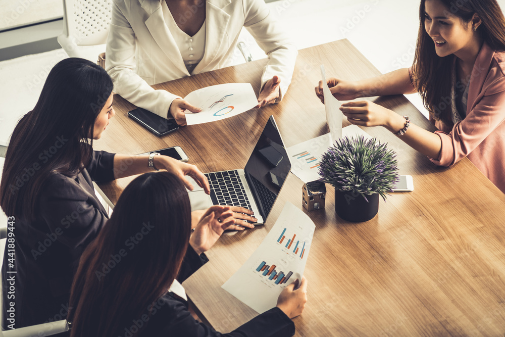 Businesswoman in group meeting discussion with other businesswomen colleagues in modern workplace of