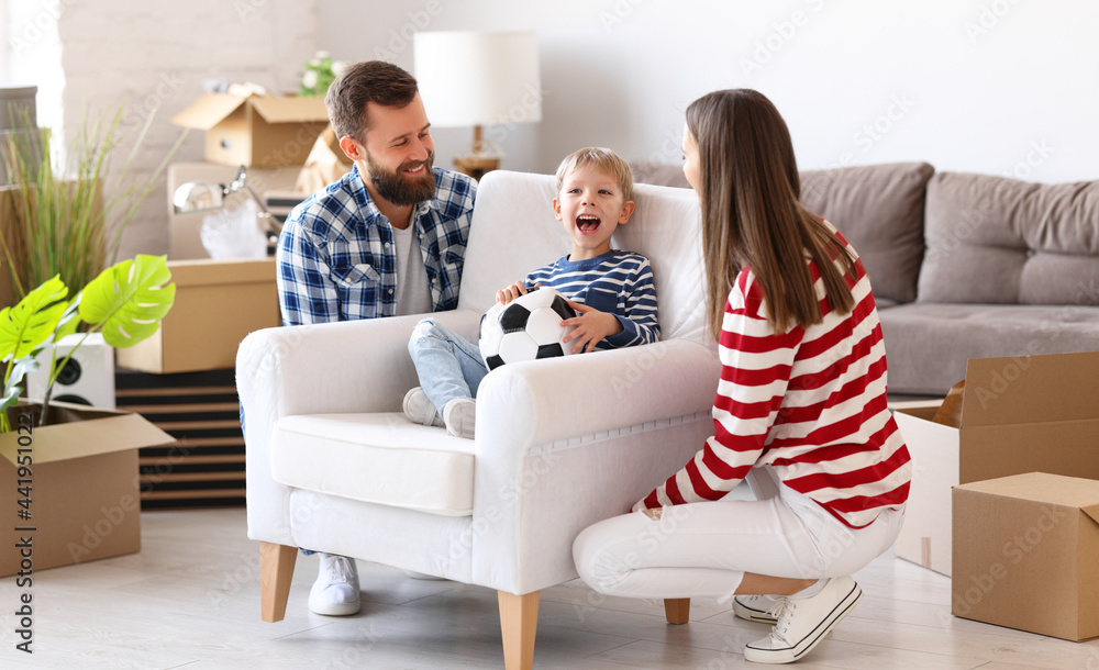 Mother and father carrying armchair with son in new apartment