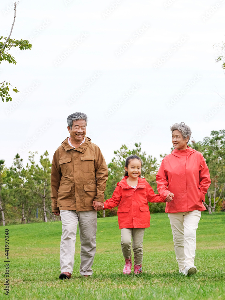 快乐的爷爷奶奶和孙子孙女在公园里散步