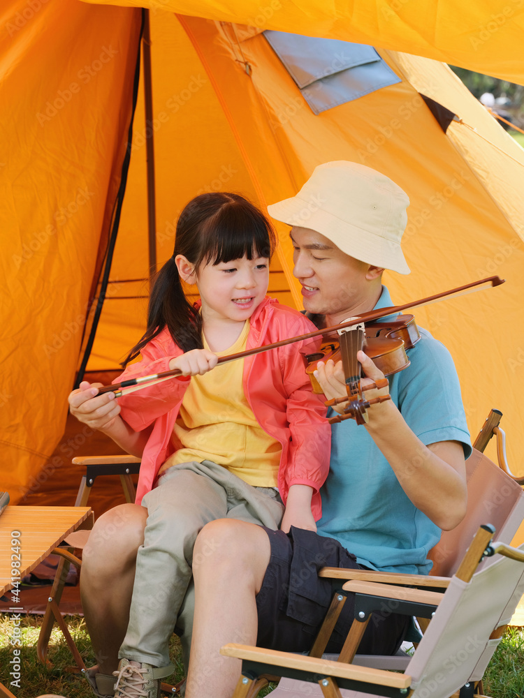 The young father taught his daughter to play the violin