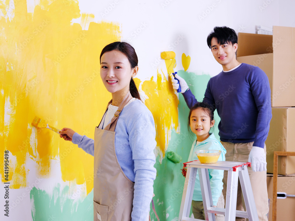 A happy family of three painting walls