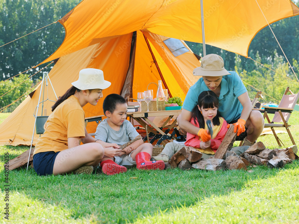 A Happy family of four camping outdoors