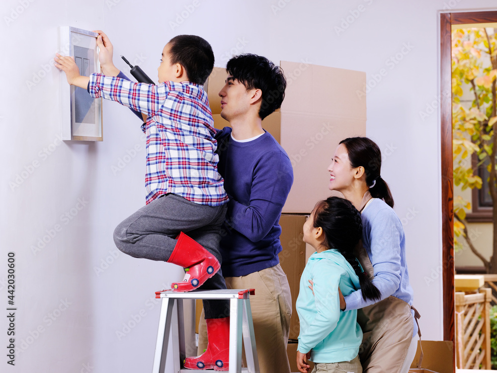 A happy family of four decorates their house