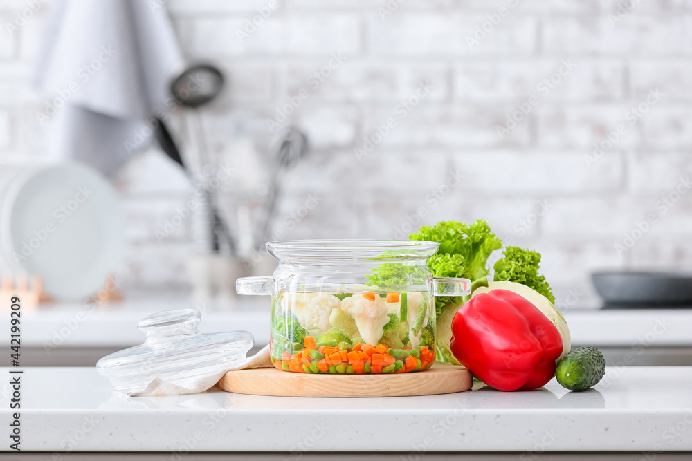 Stylish cooking pot with tasty soup on kitchen counter