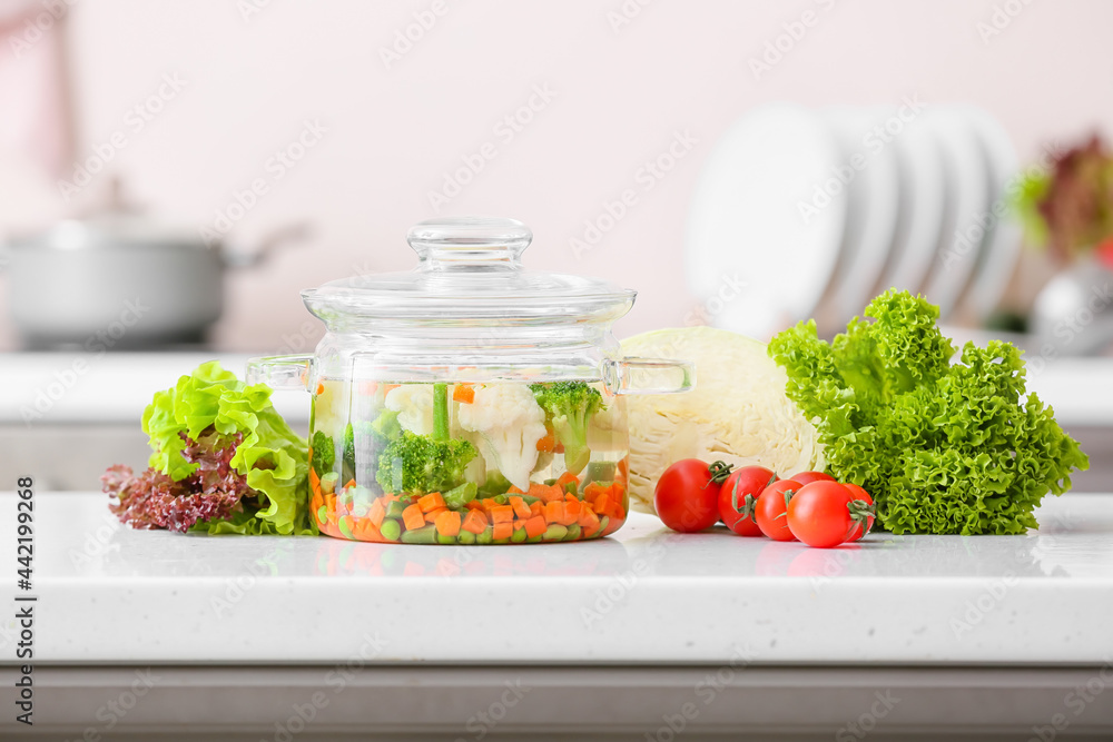 Stylish cooking pot with tasty soup on kitchen counter